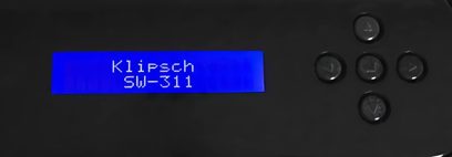 Blå LCD-skærm, der viser "Klipsch SW-311" og 5 sorte kontrolknapper på en mat sort overflade