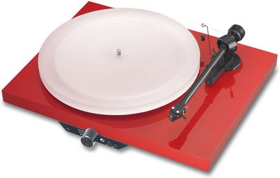 Pro-Ject Juke Box pladespiller i sort lakeret finish, tonarm, hvid pladespiller på en kraftigt rød sokkel, 3/4 ovenfra-vinkel