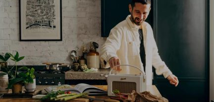 White Roberts portable radio with handle on kitchen worktop, man in background