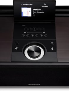 Primare Alles-in-één, zwarte hifi-installatie, bovenaanzicht, glanzend paneel met display, grote aluminium knop, stoffen grille