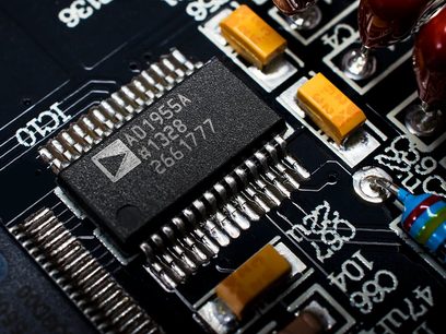 Elektronisk printplade med komponenter, chips, kondensatorer og forgyldte stik på sort baggrund