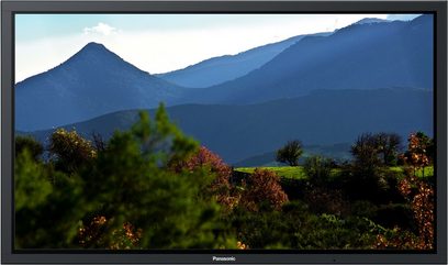 Panasonic TH-85PF12E-fladskærm, der viser et bjerglandskab med træer med efterårsfarver i forgrunden