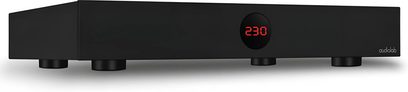 Condicionador de corriente Audiolab DC-BLOCK 6 negro con pantalla digital roja "230" en el centro y 4 patas circulares negras