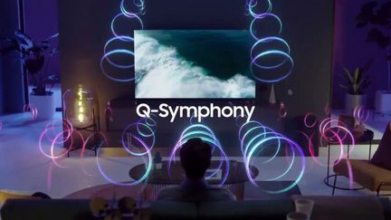 Skærm der viser "Q-Symphony" omgivet af blå og lilla neonlys der danner spiraler på en mørk baggrund