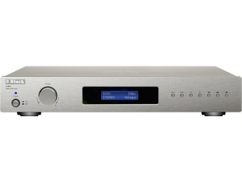 Vooraanzicht van de zilverkleurige Block R-250 tuner in geborsteld aluminium, grote draaiknop en blauwe LED links, centraal geplaatst blauw verlicht display, rij kleine ronde knoppen rechts