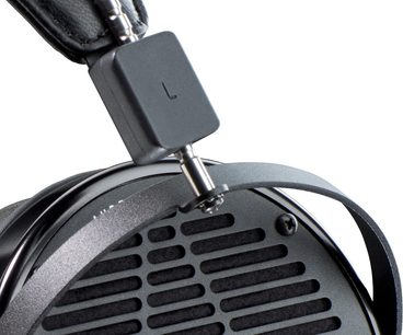 Juodos spalvos Audeze LCD-X ausinės, pamuštas lankas, ovalo formos keitikliai, perforuotas metalinis grotelių dangtelis, profilio artimas vaizdas