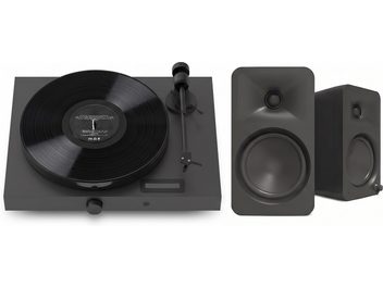 Svart platespiller med vinylplate og tonearm, ledsaget av to kompakte svarte høyttalere