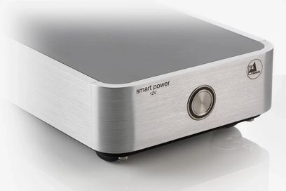 Ekstern Smart Power 12V sølv ClearAudio strømforsyning i børstet aluminium, set forfra i let frøperspektiv, med knap og jackstik på forsiden