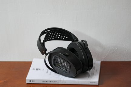 Svart åpen hi-fi-hodetelefon, ovale øreklokker med metallgitter og perforert, opphengt hodebøyle