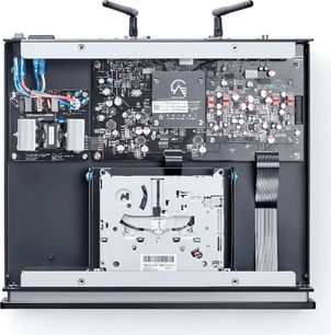 Interior de uma caixa eletrônica aberta com placas de circuito impresso, componentes, cabos e uma unidade de disco óptico