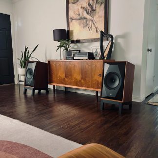 Paire d’enceintes hi-fi en bois noyer sur pieds noirs, style vintage, de part et d’autre d’un buffet rétro