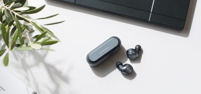 Åbne Technics EAH-AZ60 hi-fi hovedtelefoner i sort og sorte in-ear hovedtelefoner, set forfra, liggende på en hvid overflade