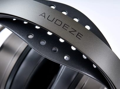 Primo piano di cuffie hi-fi Audeze con archetto in metallo grigio e fascia interna nera traforata