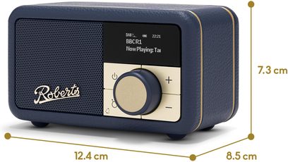 Lille bordradio Roberts Revival Petite 2 i marinblå, æske i struktureret kunstlæder med afrundede kanter og gyldne kanter, højttalergrill med metal-logo, sort skærm og gyldent kontrolpanel med stor central drejeknap, set fra venstre forside i trekvarts vinkel