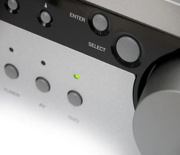 Close-up view of the front panel of a black Arcam DIVA-A90 hi-fi stereo amplifier with control knobs and an illuminated green indicator light