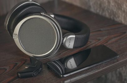 Auriculares cerrados circumaurales Hifiman Deva Pro en negro y plata, con transductores de diafragma ancho, colocados sobre una superficie de madera oscura