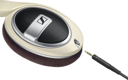 Åben hi-fi hovedtelefon Sennheiser HD-599 i beige og brun, set fra venstre profil, placeret på stander, med sort jackstik-kabel