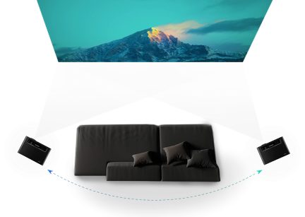 Svart sofa sett forfra foran et snødekt fjell opplyst av solen mot en blå himmel, digitalt bilde