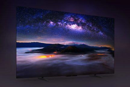 Televisore a schermo piatto nero su piedistallo, con paesaggio vulcanico notturno sotto la Via Lattea