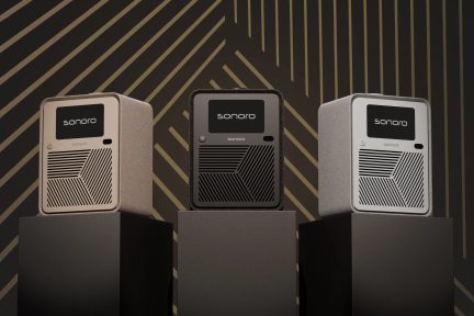 Three compact Sonoro radios with black screens and geometric grilles, in beige, black and white