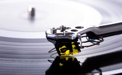 Černá vinylová buňka Rega Aphelion 2 MC, detailní pohled shora, viditelné rameno a kabely na vinylové desce