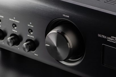 Ampli hi-fi stereo Denon PMA-1700NE černý. Přední panel s tlačítky, ovládacím kolečkem hlasitosti a konektorem pro sluchátka. Detailní záběr, pohled zepředu.