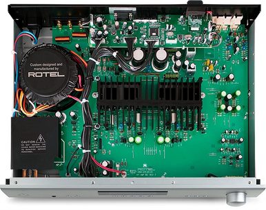 Indvendigt syn af en Rotel A11 Tribute Edition sølvfarvet hi-fi stereoforstærker, der viser de elektroniske komponenter på et grønt printplade