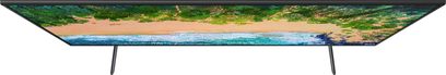 Samsung UE49NU7105 ultratyndt fladskærms-TV, der viser en strækning af fint, hvidt sand og et turkisfarvet hav under en klar, blå himmel