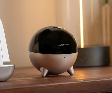 Ayaklı, siyah ve gümüş renkli küresel Sofabaton hub, ahşap mobilya üzerinde önden görünüm