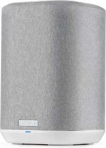 Witte Denon Home 150 slimme luidspreker met compact cilindervormig design, lichtgrijze stoffen voorkant en minimalistische witte voet