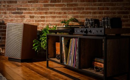 Audio nábytek ze dřeva a černého kovu, šikmý pohled, gramofon a lampový zesilovač, reproduktor s dřevěným tělem a látkovou mřížkou, uspořádané desky