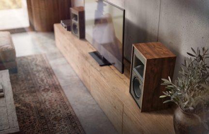 Diffusore da scaffale vintage con finitura in legno scuro, posato su un mobile TV in un soggiorno moderno