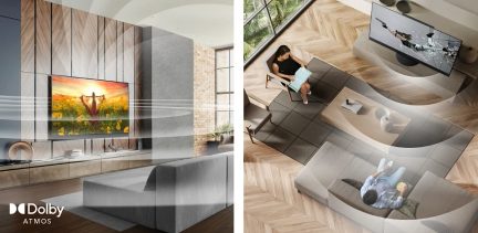 Salon moderne avec canapé gris, table basse, télévision, femme assise travaillant sur ordinateur portable, parquet chevron