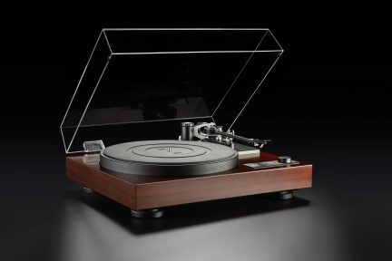 Giradischi hi-fi con finitura in legno scuro con coperchio trasparente sollevato, vista a tre quarti