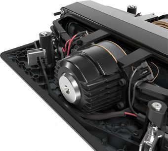 Caisson de basses encastrable SFC-12-SW, vue en gros plan, moteur central cylindrique noir avec ailettes, câbles rouges et noirs connectés, structure métallique noire, composants mécaniques et électroniques visibles, base perforée noire