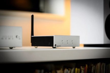 Odtwarzacz sieciowy Pro-Ject Stream Box E czarny i srebrny z anteną Wi‑Fi, widok z przodu na półce