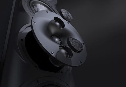 Primo piano di un diffusore nero in metallo, cassa smontata, diversi altoparlanti e griglie forate