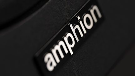 Pirmas planas juodos plastikinės plokštelės su baltu iškilu įrašu „amphion“, įstrižas kampas