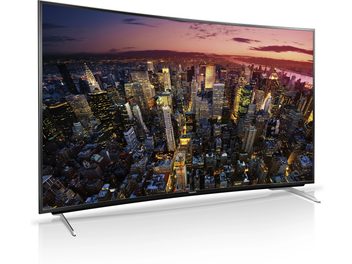 Panasonic TX-65CR730E TV displaying a night aerial view of a large illuminated city with numerous skyscrapers