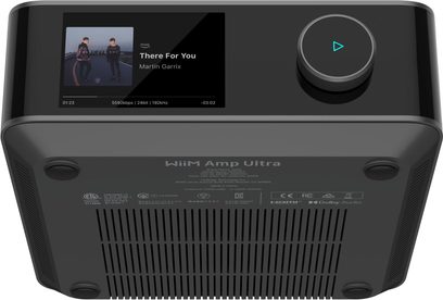 Stereo hi-fi integrirani ojačevalnik WiiM Amp Ultra v črni kovinski ohišju, posnetek iz spodnjega kota prikazuje zgornji barvni zaslon, velik osvetljen vrtljiv gumb ter spodnji del z nogicami in prezračevalnimi režami