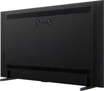 Černý televizor TCL 98C7L při pohledu zezadu, velká plochá obrazovka s bočními nožkami a mřížkovaným zadním panelem