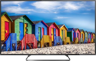Panasonic TX-55CX680E-fladskærm, der viser en række farverige strandkabiner på en sandstrand