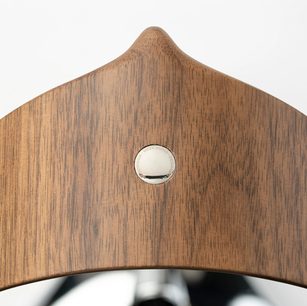 Aksesuārs HI-FI austiņām Meze Audio, Manta austiņu statīvs hroma izdevums, koka konstrukcija ar dabīgu apdari, tuvplāns, kurā redzams gravēts metāla aplis, teksturēta virsma ar redzamu koka šķiedru, izplūdis fons
