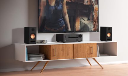 Vit skandinavisk TV-bänk i trä med svart hemmabioförstärkare och två kompakta hi-fi-högtalare på sidorna
