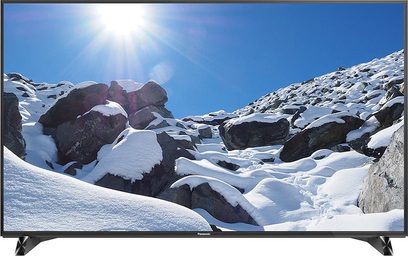 Téléviseur Panasonic TX-58DX900E affichant un paysage enneigé et rocheux sous un ciel bleu avec quelques nuages