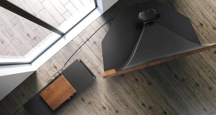 Black suspended range hood above a wooden countertop in a modern interior with a wood slat ceiling