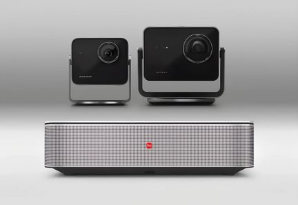 Pilkas Leica vaizdo projektorius su perforuotu priekiniu skydeliu ir dviem juodomis kameromis ant laikiklio, vaizdas iš priekio