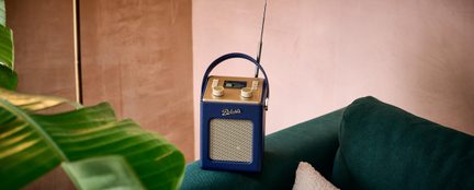 Blaues tragbares Radio mit strukturierter Beschichtung, goldener Oberseite, Metallgitter, 2 Tasten, Display, Griff, Antenne, Frontansicht