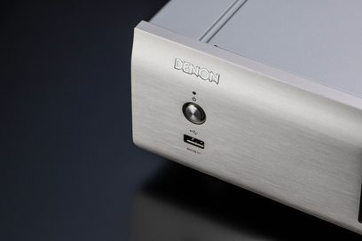 Denon DCD-900NE hopeinen CD-soitin, lähikuva yläoikeasta kulmasta, jossa "DENON"-logo on kaiverrettuna, USB-portti