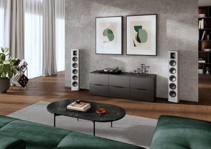Hvide hi-fi gulvhøjttalere i moderne design, der indrammer et TV-møbel med pladespiller i en moderne stue